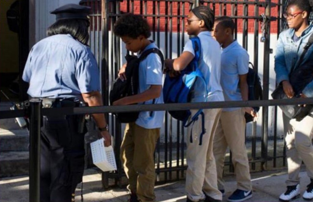 Security officer monitoring students at a school entrance